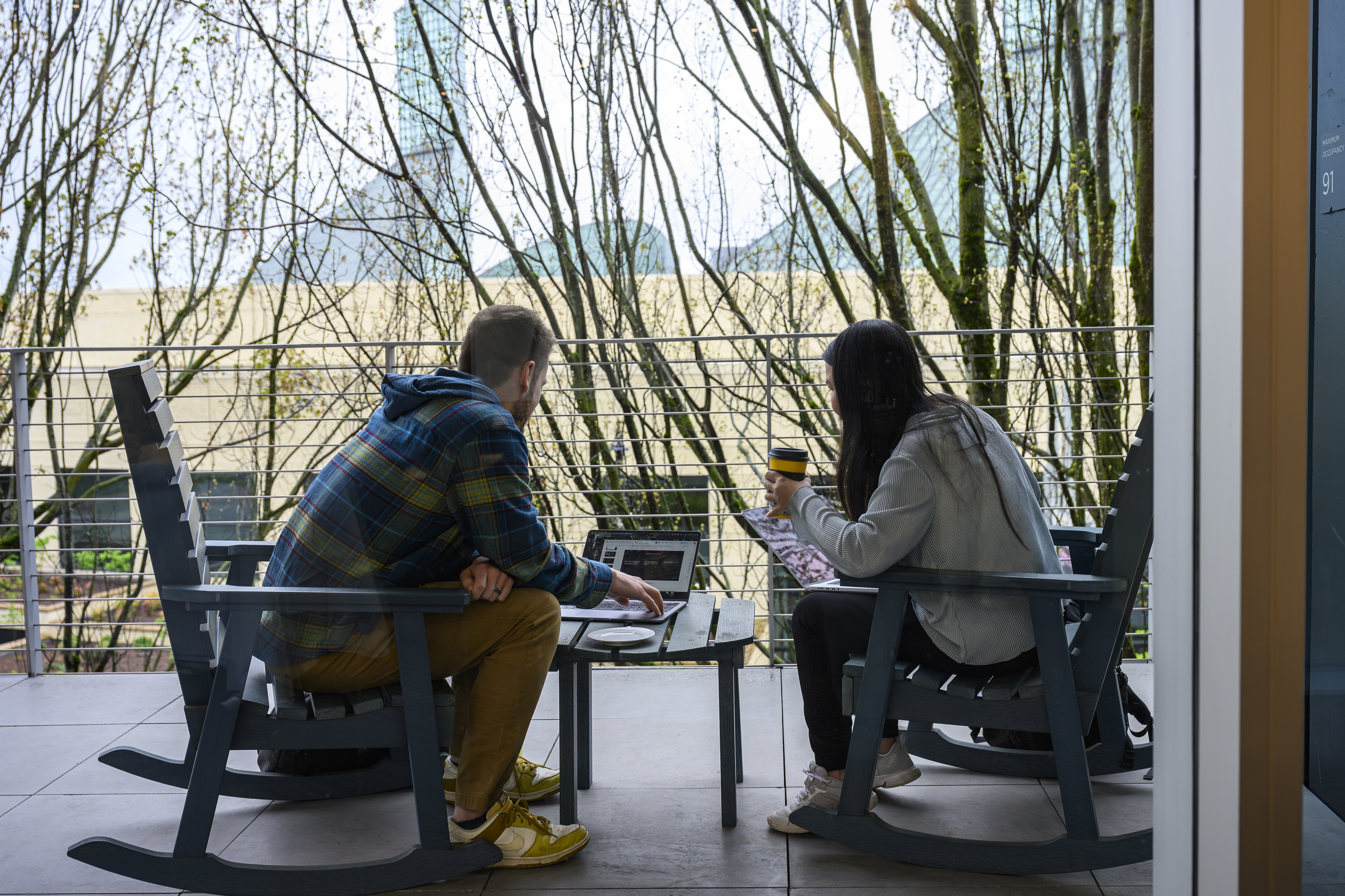 two people conversing in front of a laptop